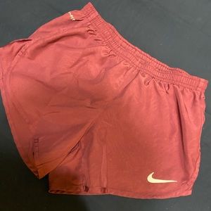 Purple/ maroon athletic shorts.